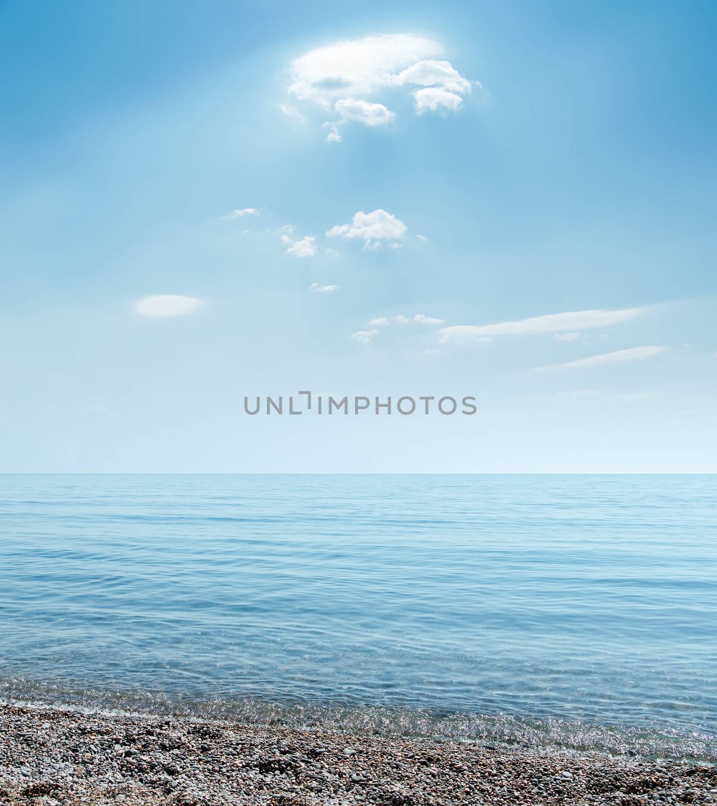 sea beach with stones under clouds by mycola