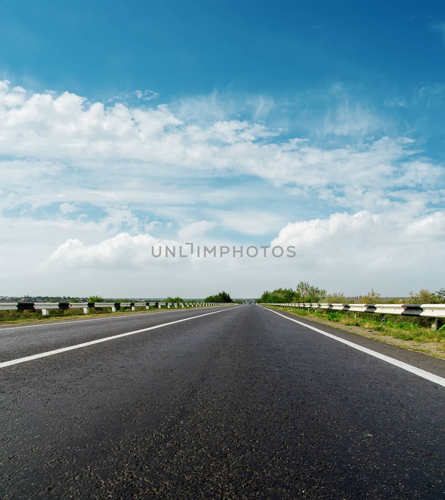 asphalt road and cloudy sky by mycola