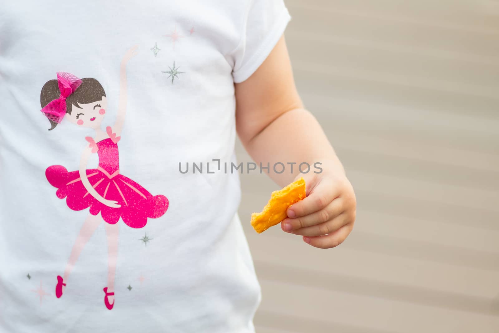 child hand holding snack.