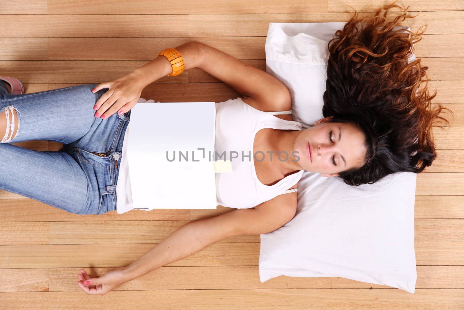 A young adult woman sleeping after reading a book.