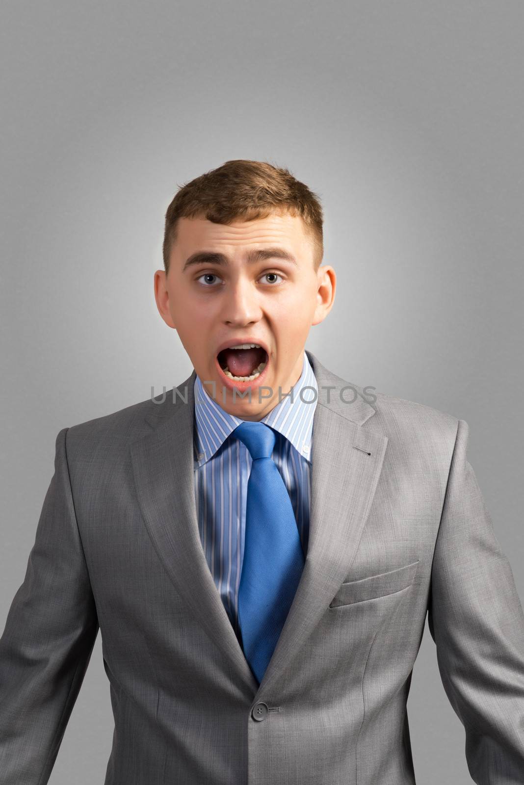 portrait of a young businessman screaming, shouting and looking at the camera