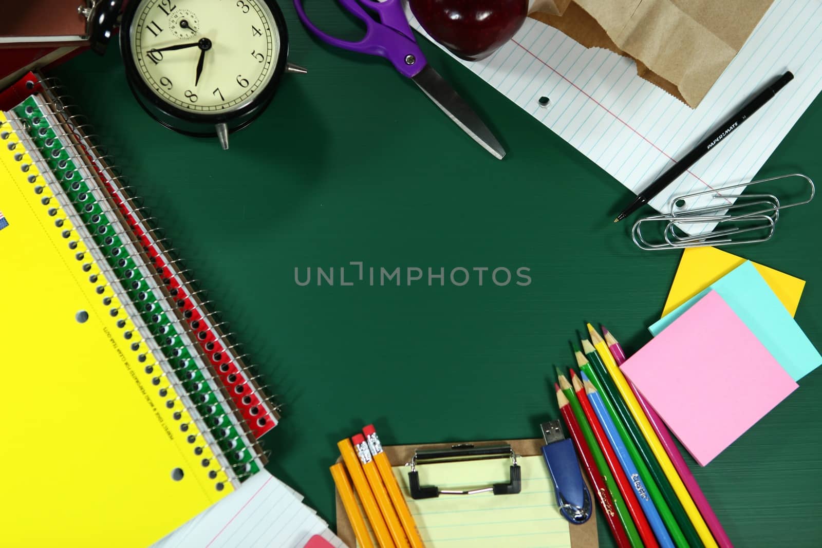 Multiple Back to School Items Arranged on a Green Blackboard