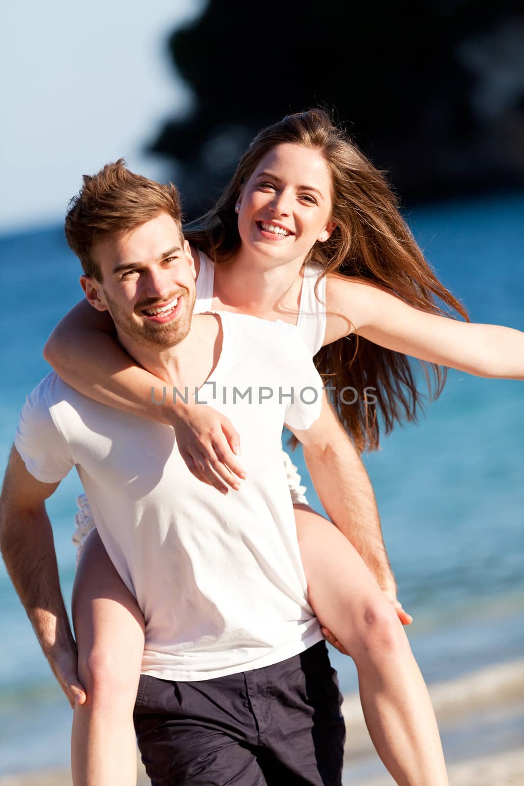 happy young couple on the beach in summer holiday love togetherness