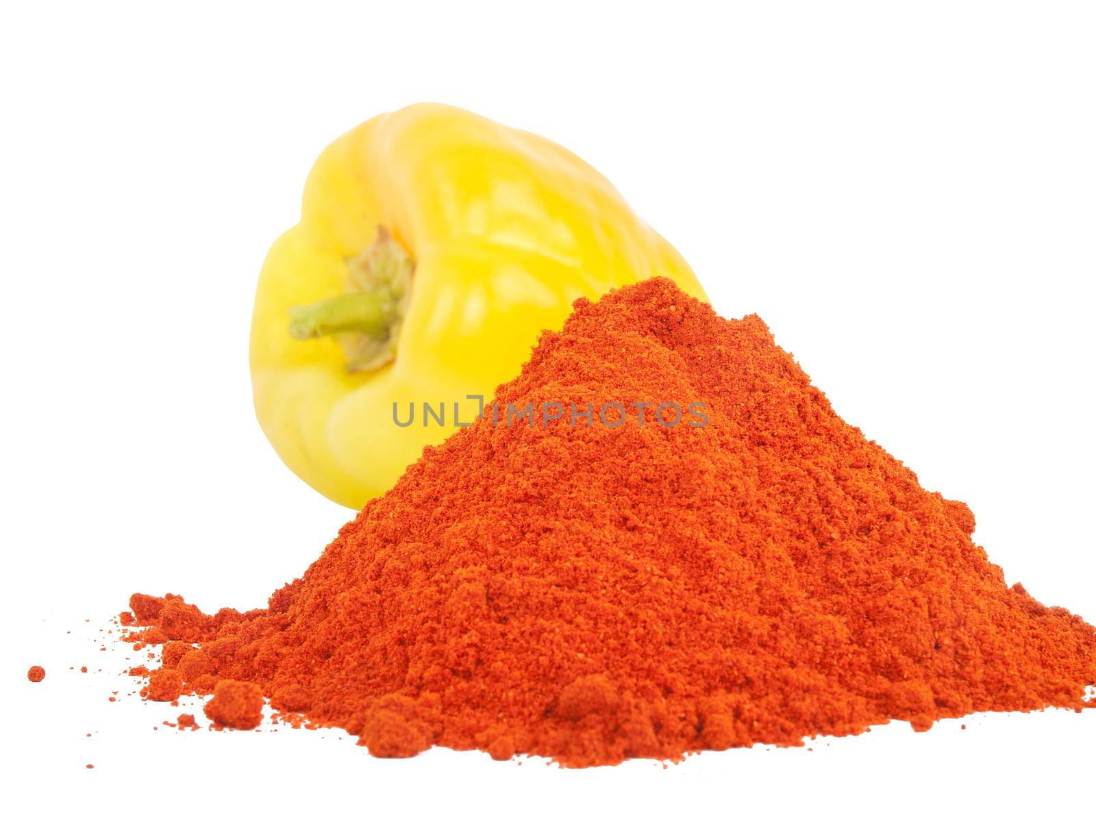 red sweet paprika powder and yellow paprika behind it