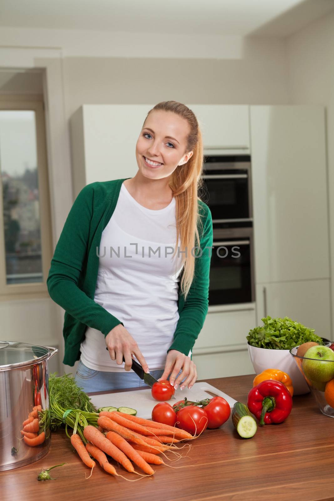 young woman cooking vegetarian food in kitchen