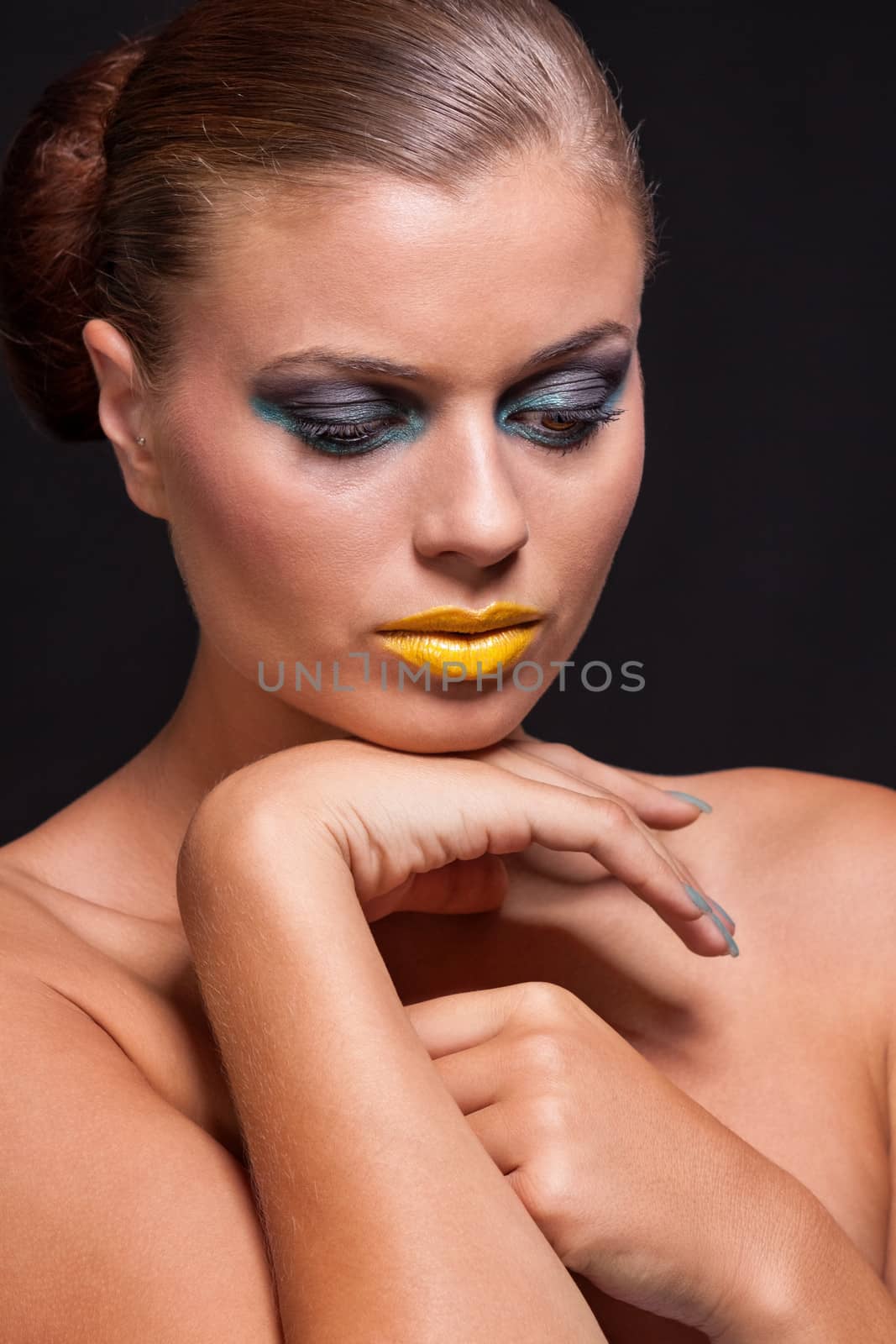woman with extreme colorfull make up in blue and yellow on black background