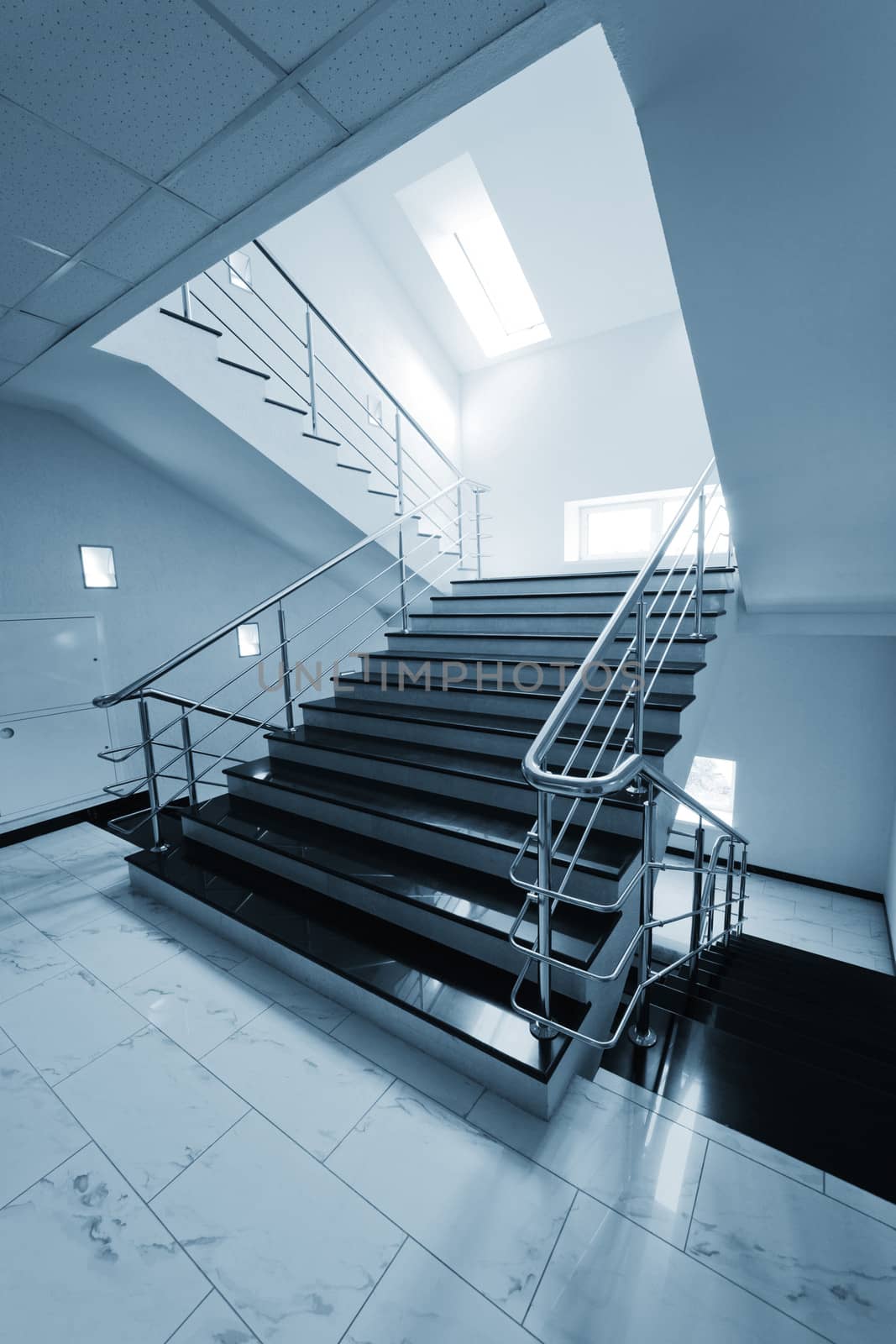 Marble staircase with a steel handrail in a modern building