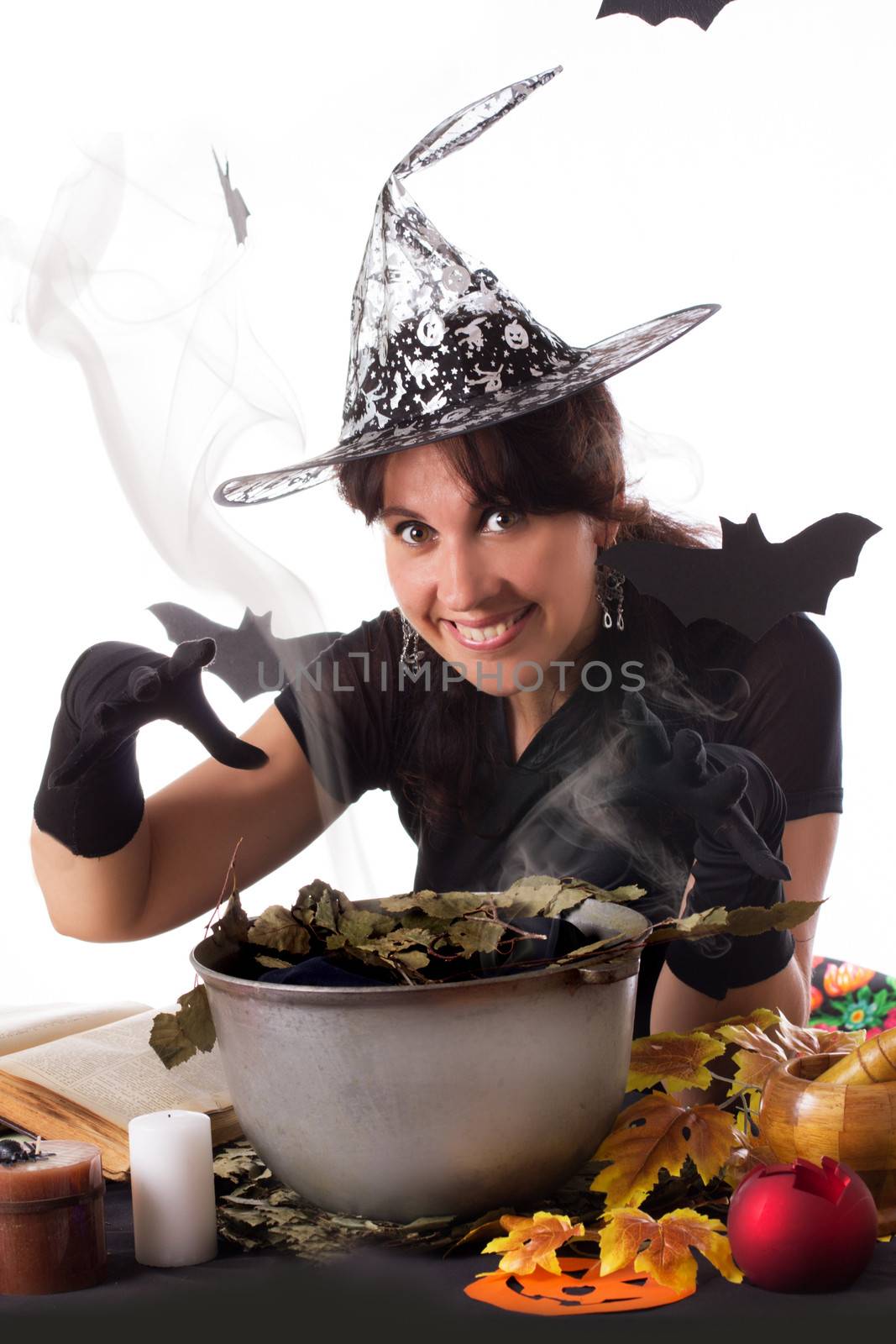 Smiling witch making magic on Halloween isolated over white