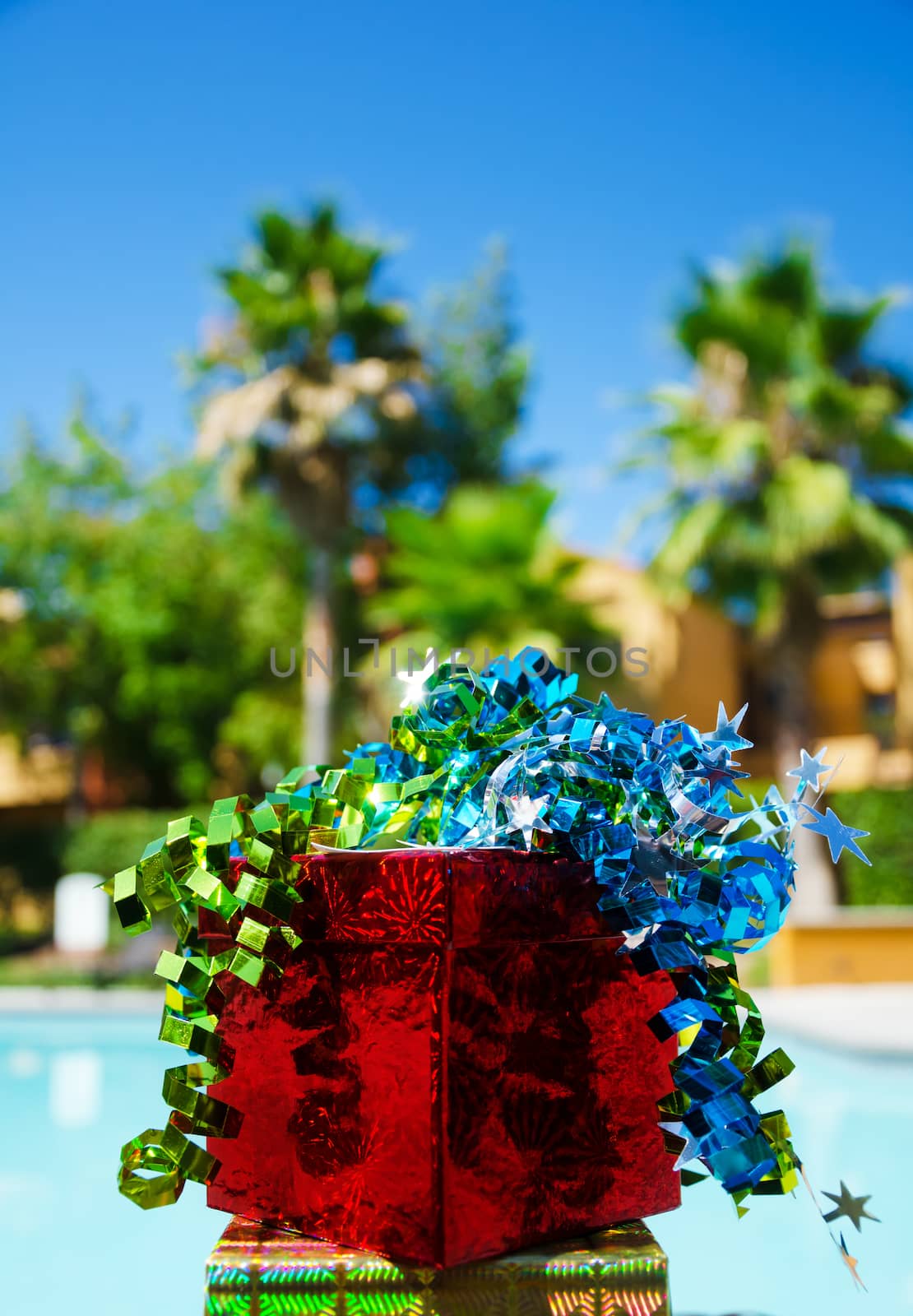 Gift box with ribbon by the swimming pool by EllenSmile
