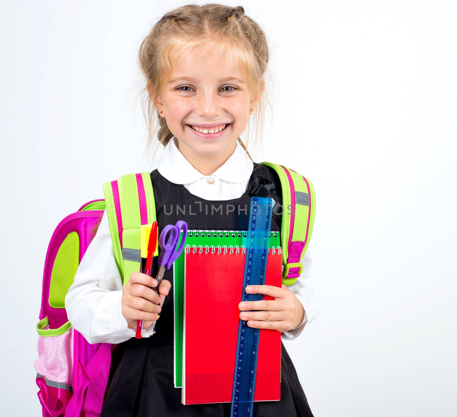 little smiling girl with stationery on a white background