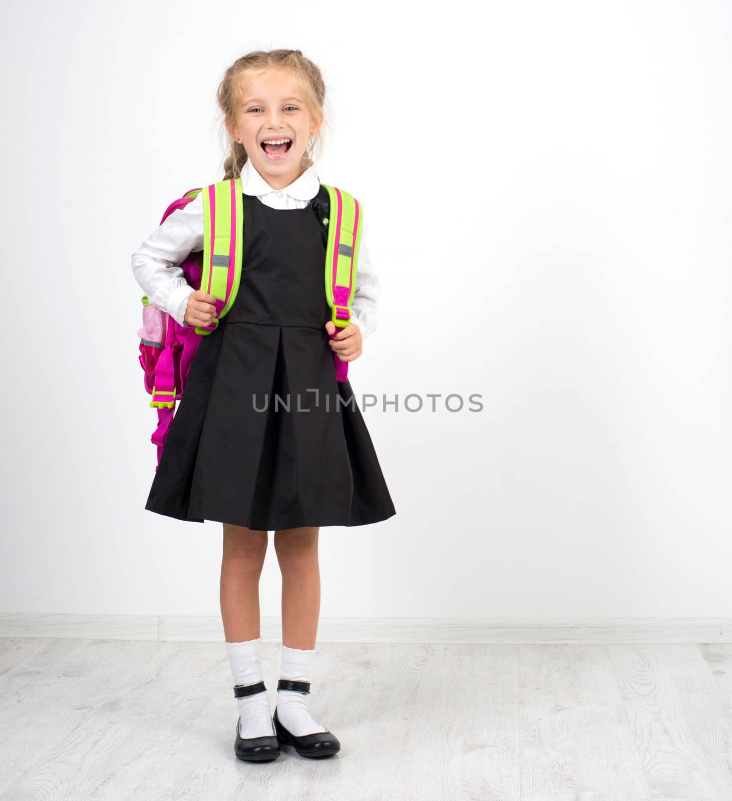 little cute girl with backpack on a white background
