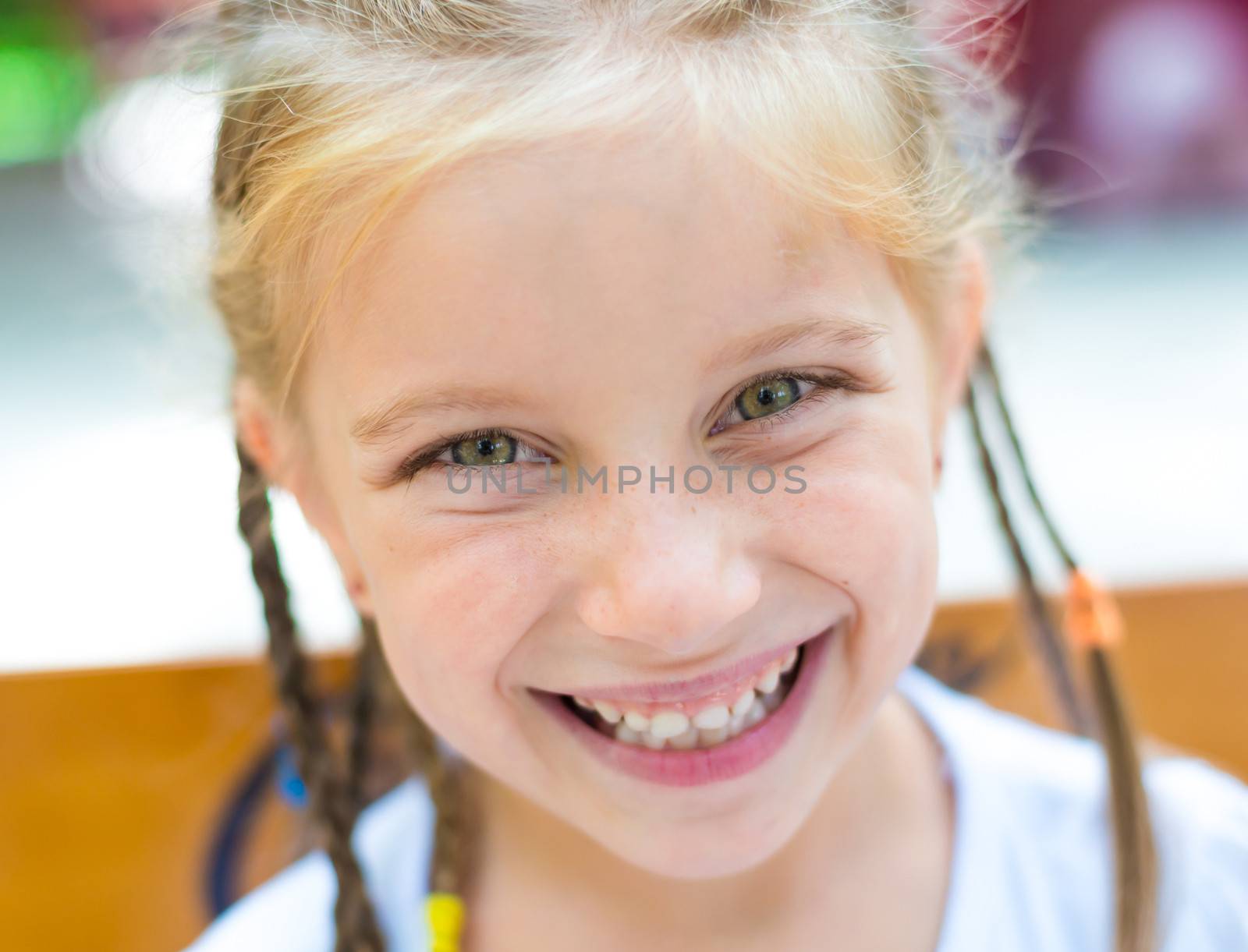 cute little girl smiling in a park close-up