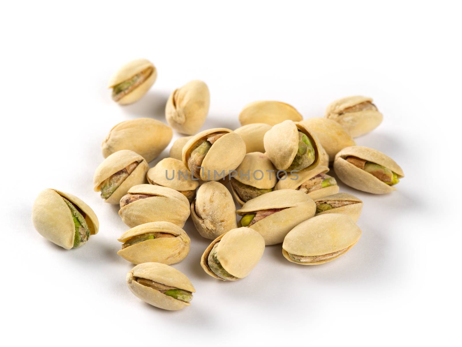 Macro photo of a small group of pistachios on a white background.