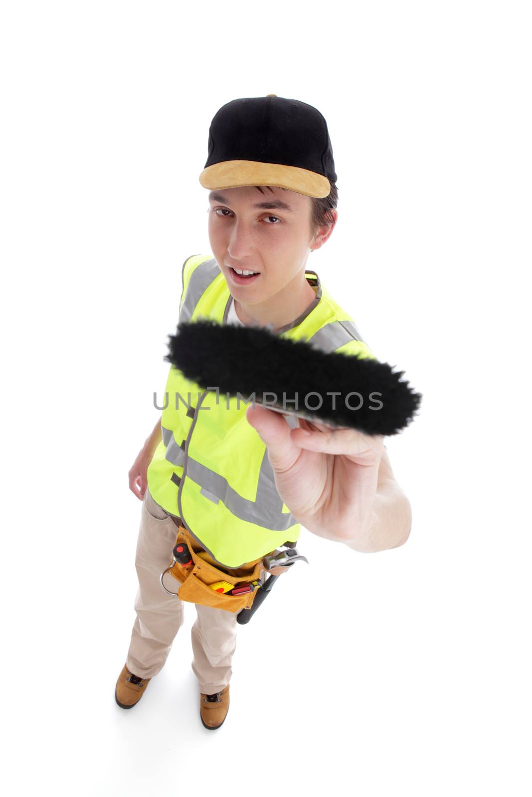 Young handyman teenage apprentice painter wearing work clothes and holding a paintbrush.  White background