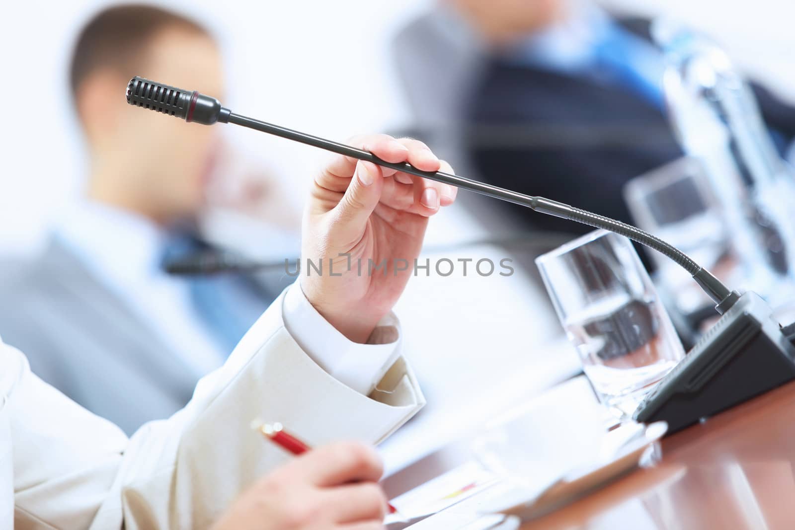 Image of businessman's hands holding microphone at conference