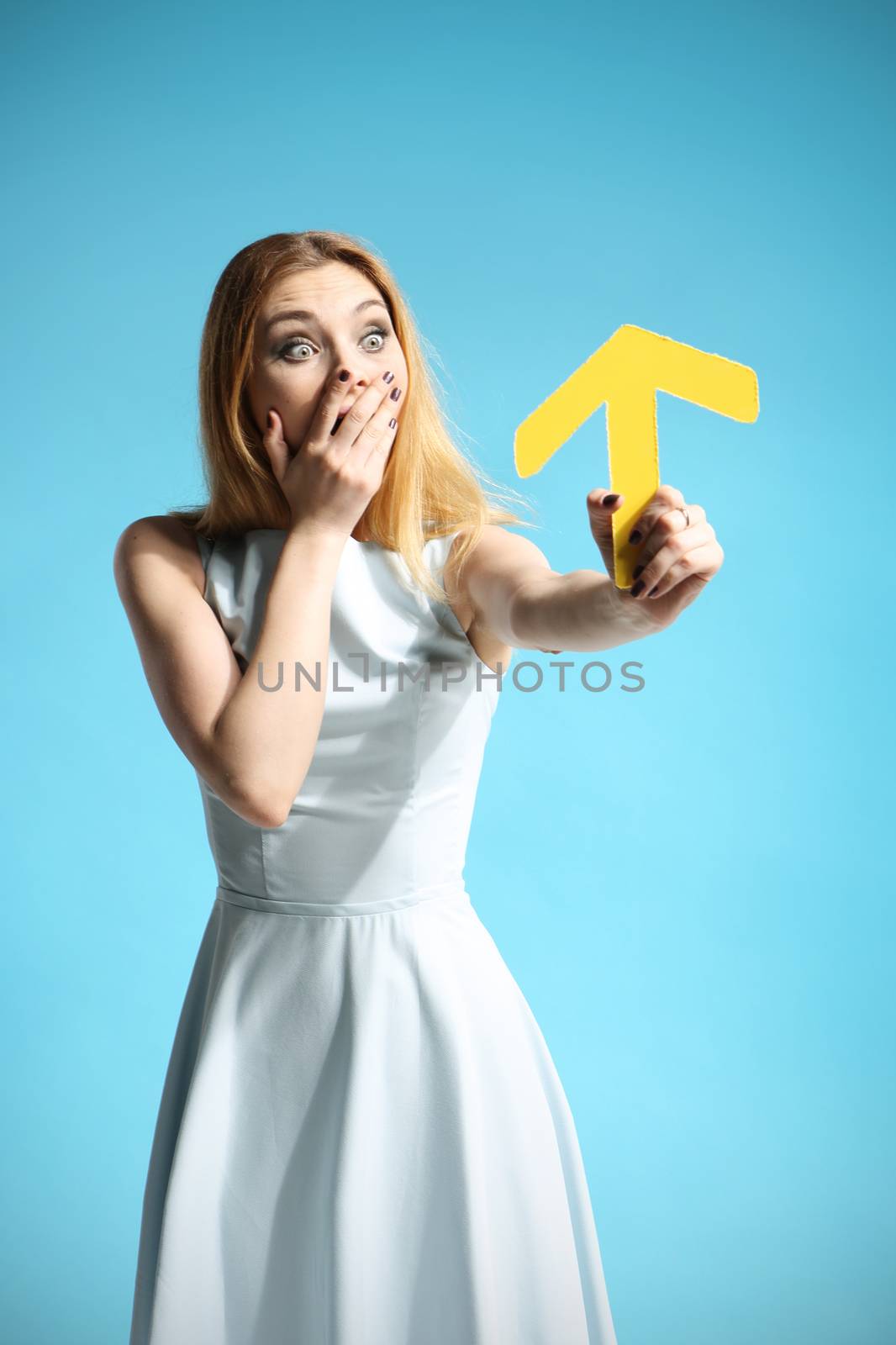 Beautiful girl in a white dress holding an arrow