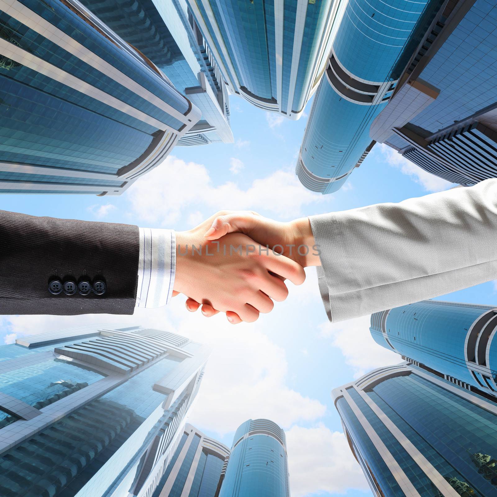 Close up image of hand shake against skyscrapers