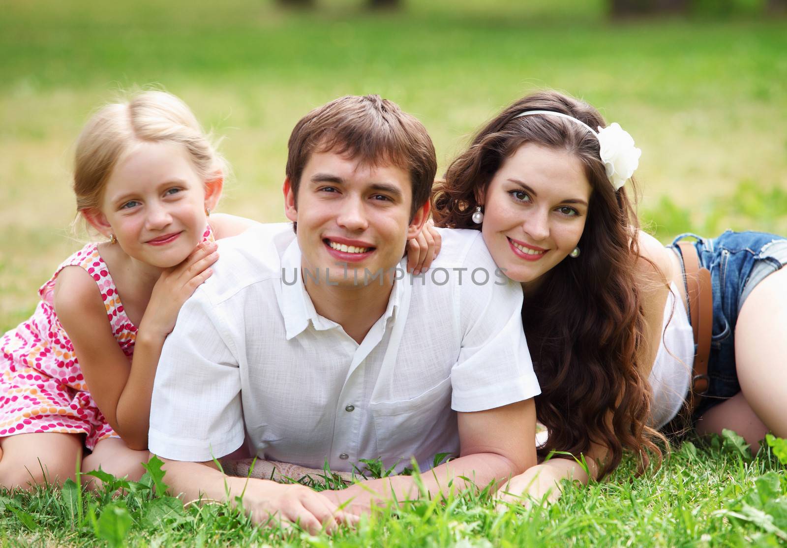 Young Family Outdoors Walking Through Park in summer