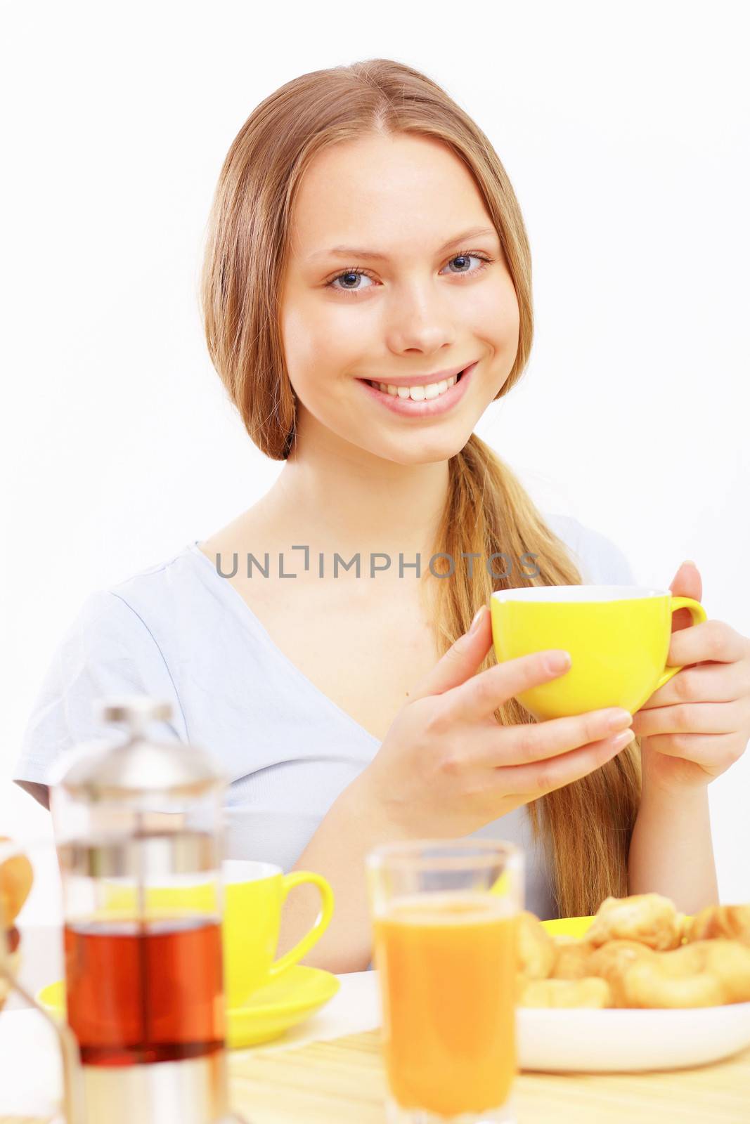 Beautiful young woman drinking tea from yellow cup