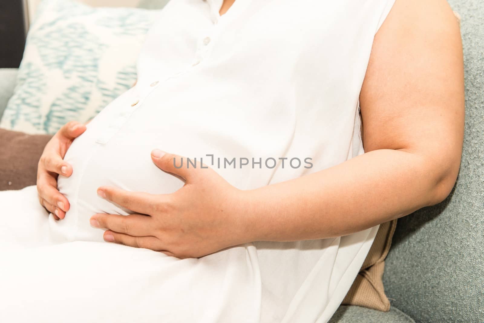 6 months Asian Thai woman pregnant belly, taken in door