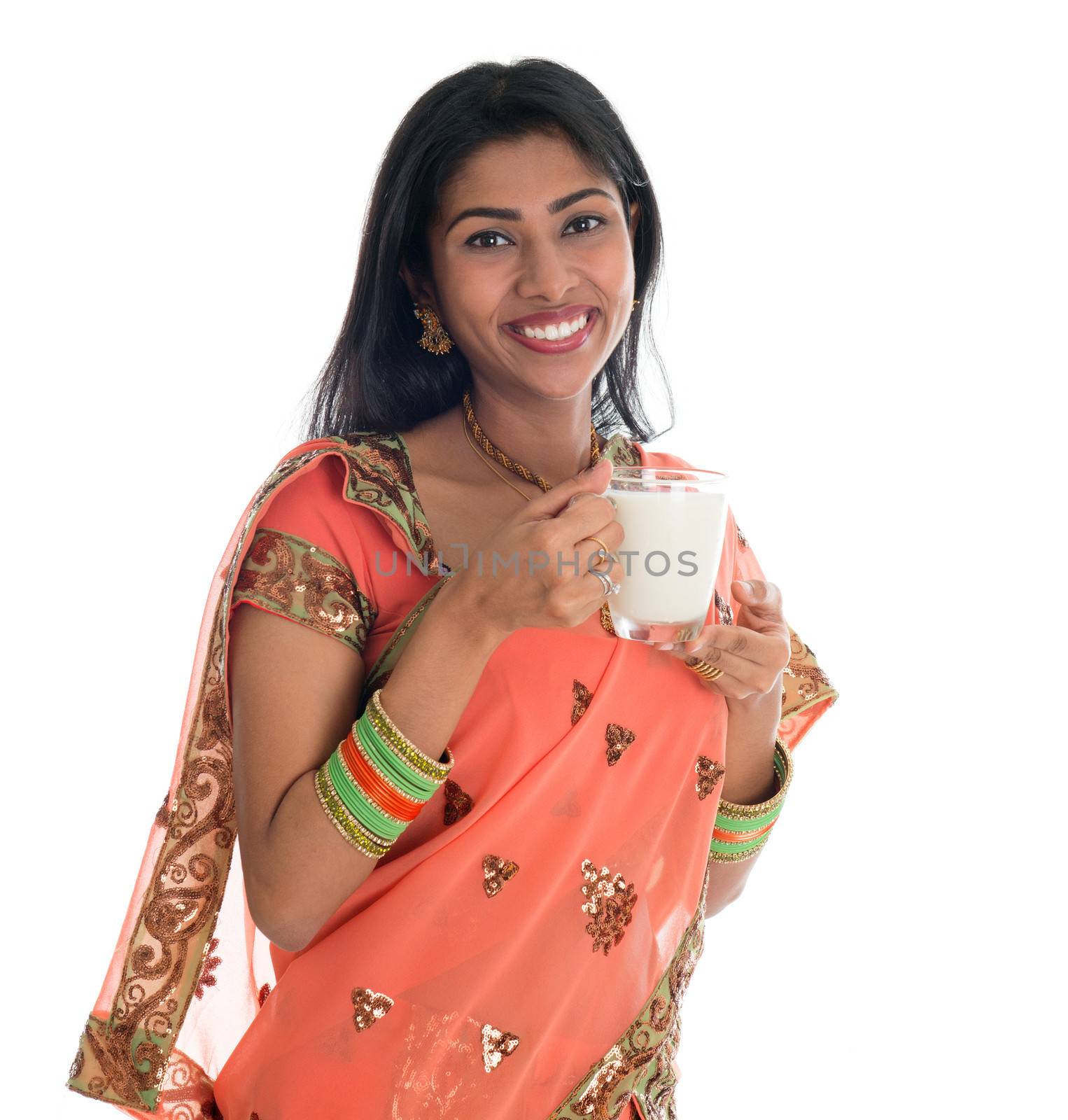 Happy Traditional Indian woman in sari drinking soy bean milk, isolated on white background.