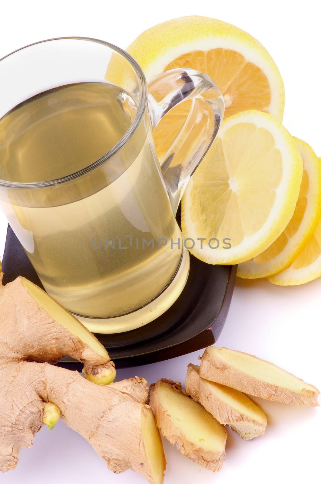 Arrangement of Glass Cup of Tea, Ginger and Lemon Slices closeup on white background