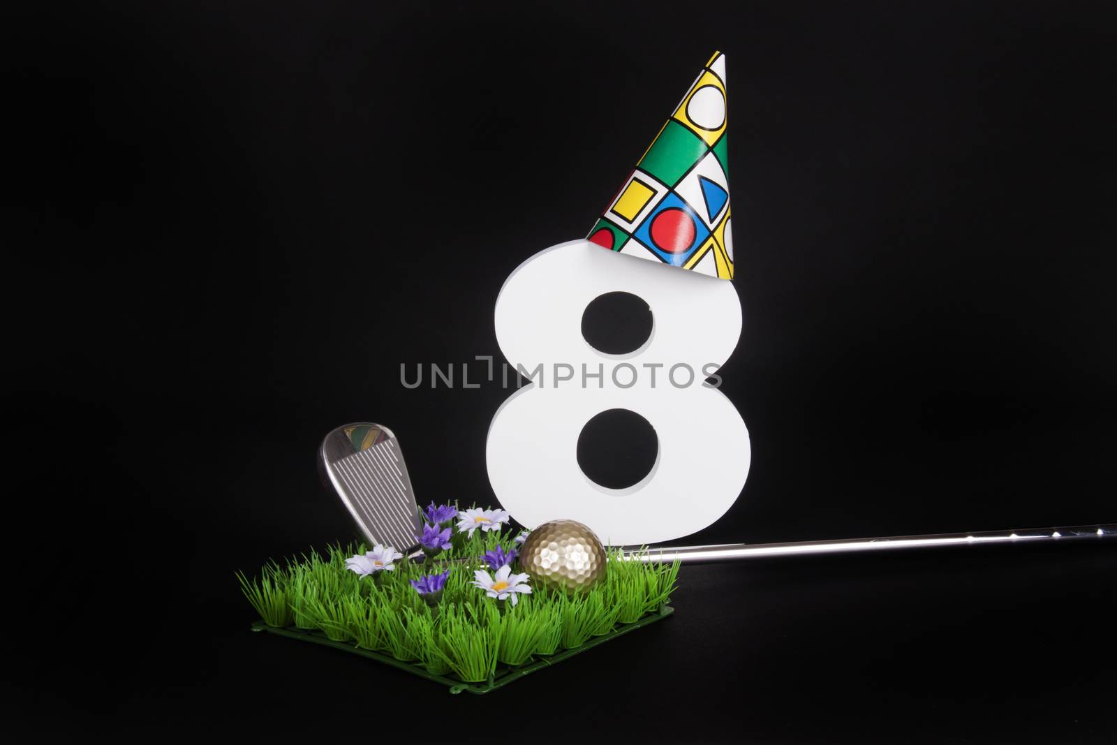 A golf club and golf ball on an artificial peace of grass to be used as a birthday card