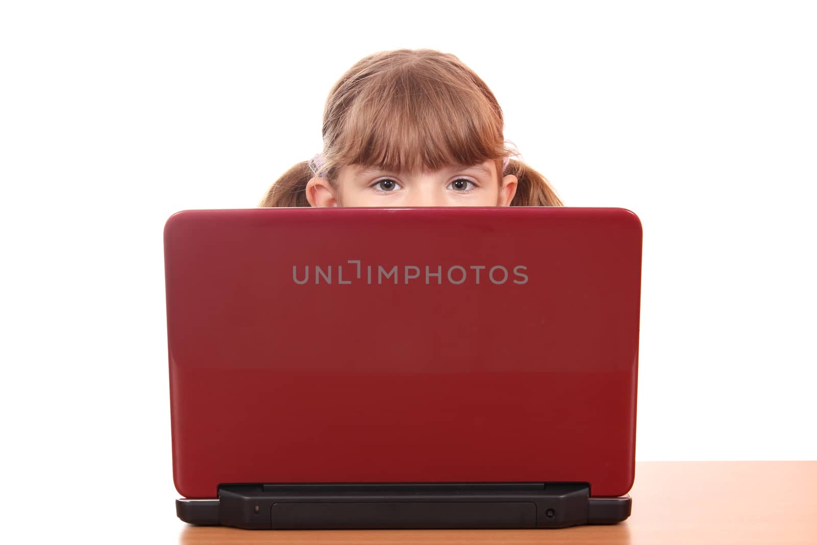 little girl looking behind laptop