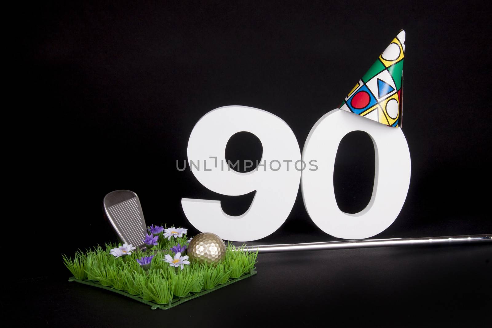 A golf club and golf ball on an artificial peace of grass to be used as a birthday card