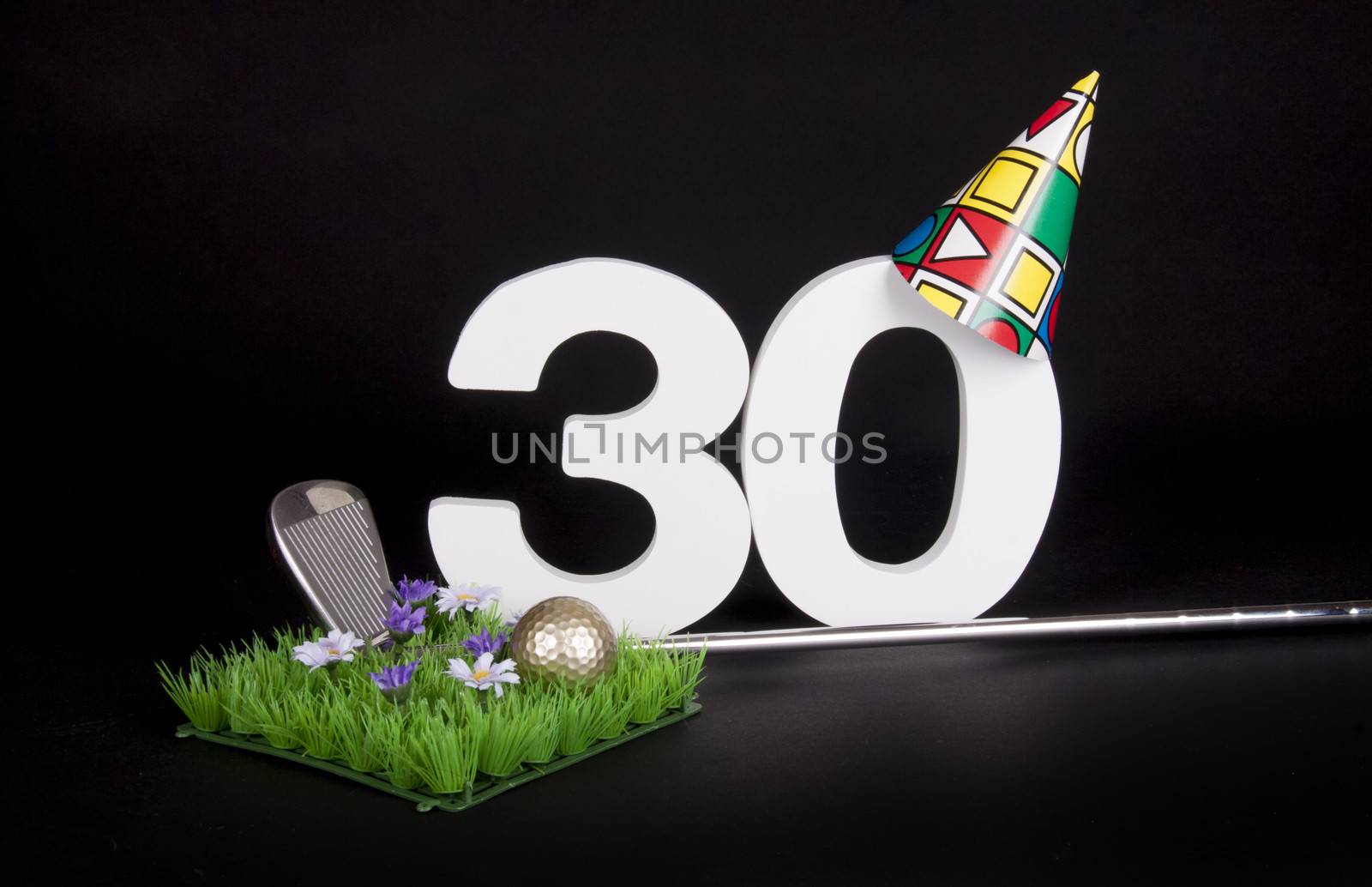 A golf club and golf ball on an artificial peace of grass to be used as a birthday card