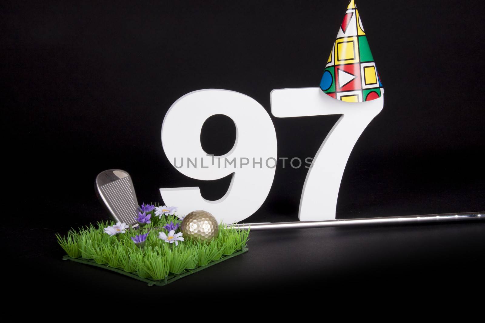 A golf club and golf ball on an artificial peace of grass to be used as a birthday card