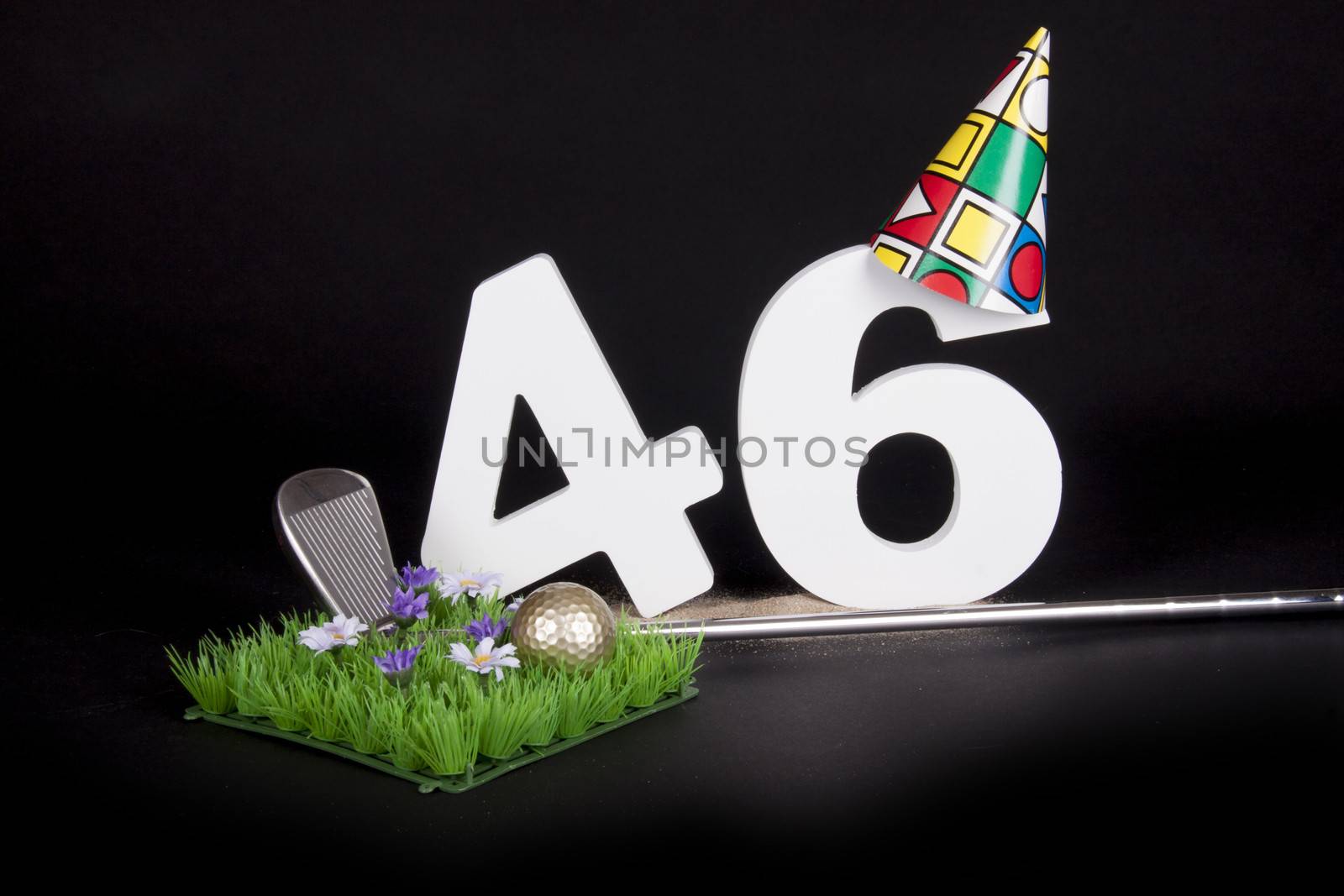 A golf club and golf ball on an artificial peace of grass to be used as a birthday card