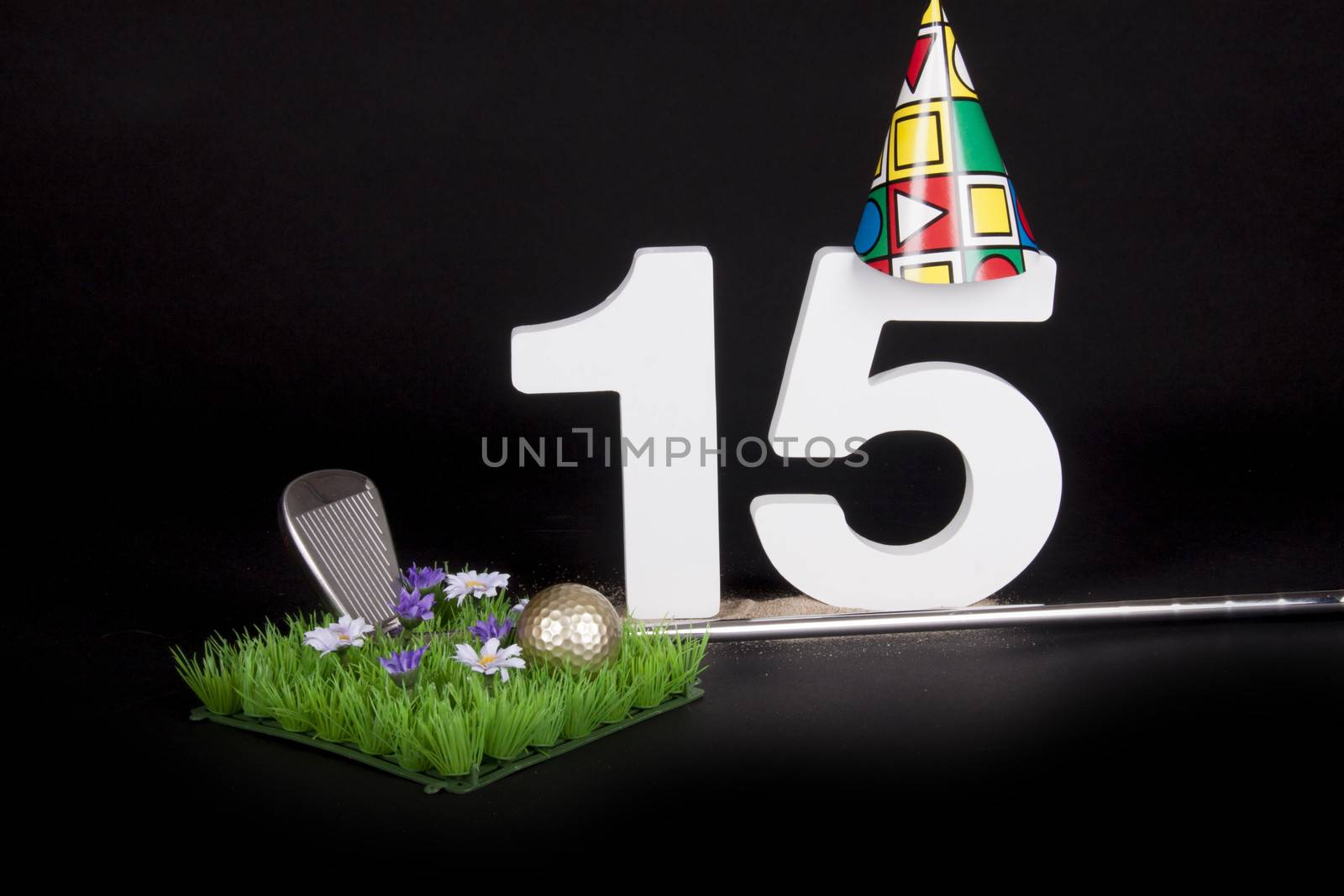 A golf club and golf ball on an artificial peace of grass to be used as a birthday card