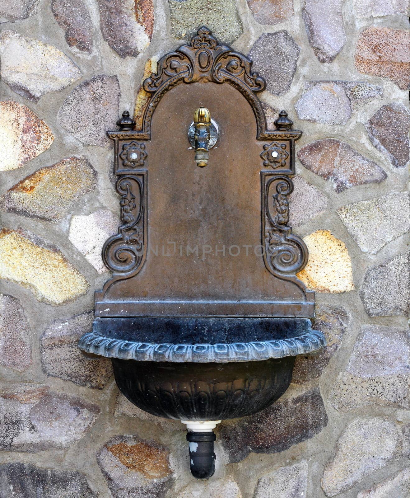 beautiful old-style fountain mounted on a stone wall