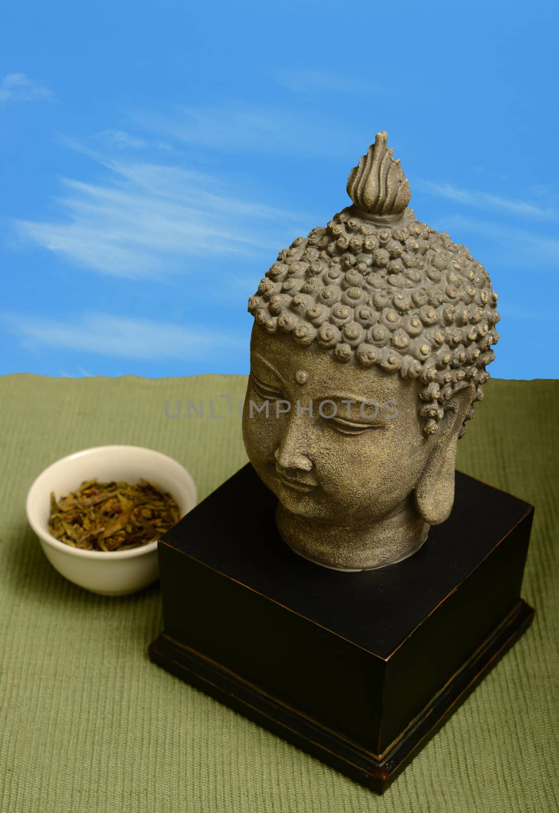 buddha statue with tea leaves against blue sky