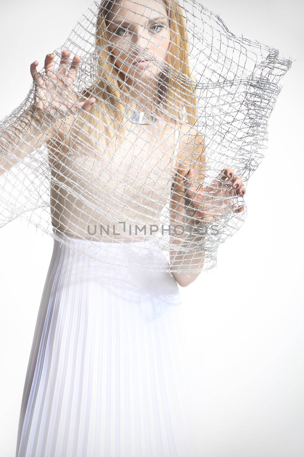 Beautiful girl in a white dress covered with a mesh isolated on white background