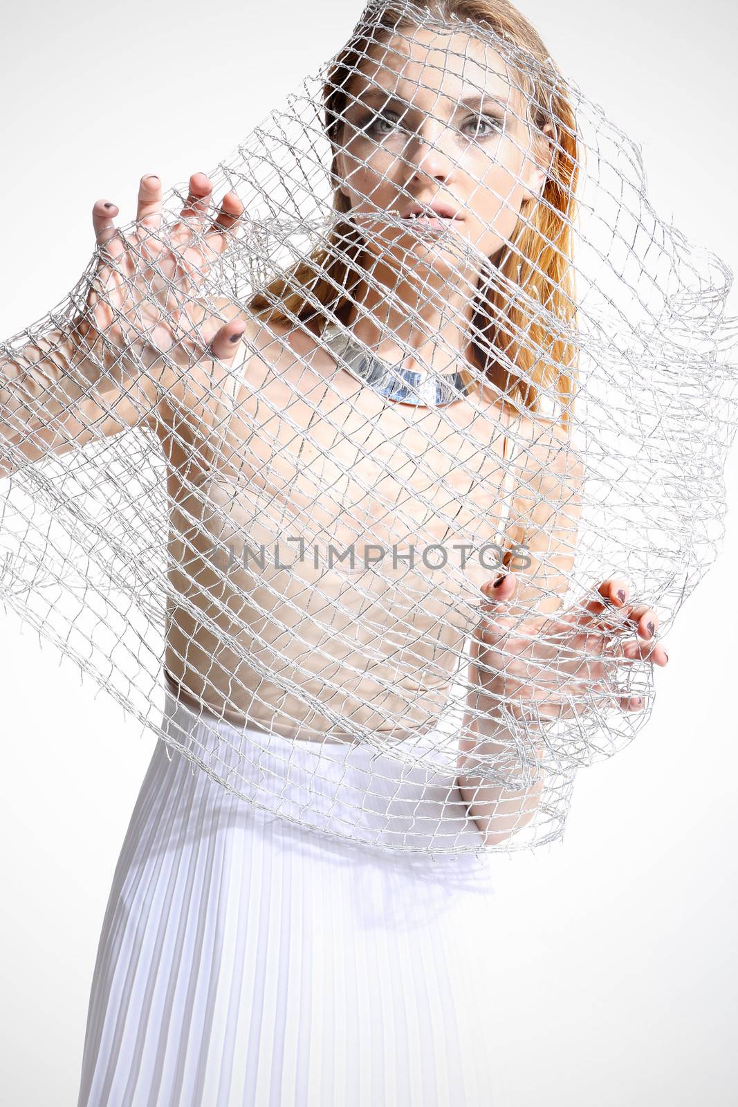 Beautiful girl in a white dress covered with a mesh isolated on white background