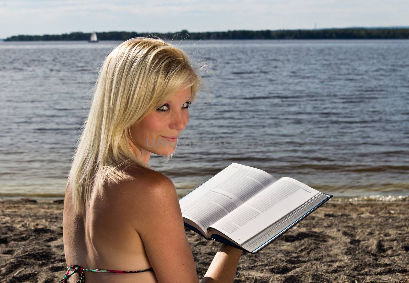 Woman reading a book on the beach