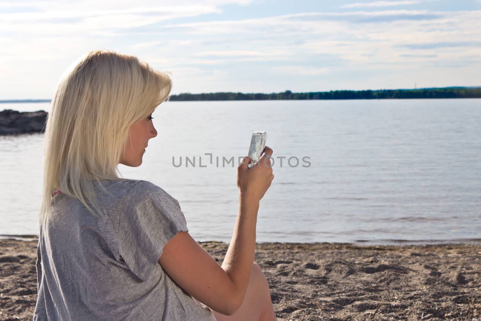 Young woman on the beach using a smart phone