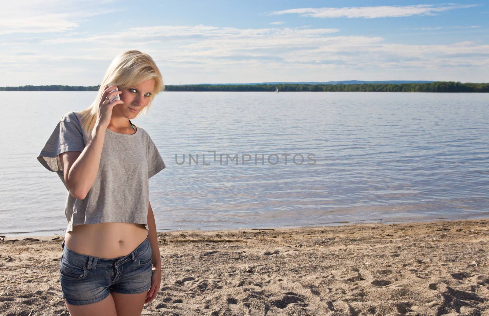 Young woman talking on smart phone on the beach