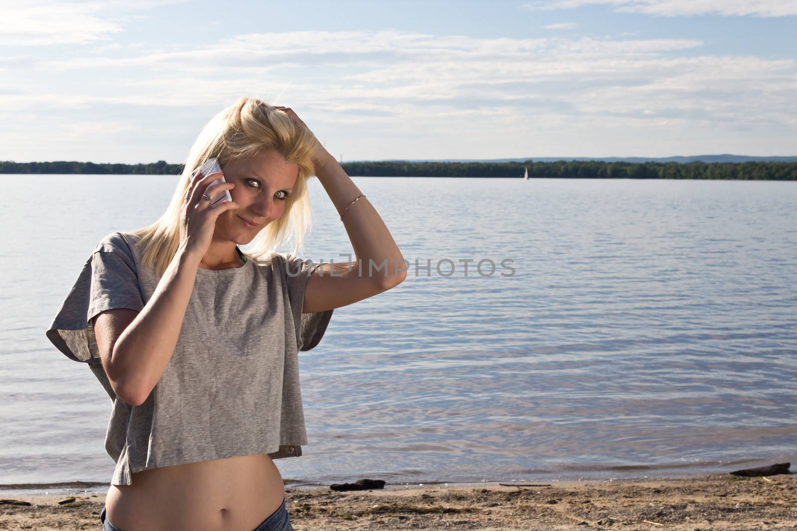 Young woman talking on smart phone on the beach