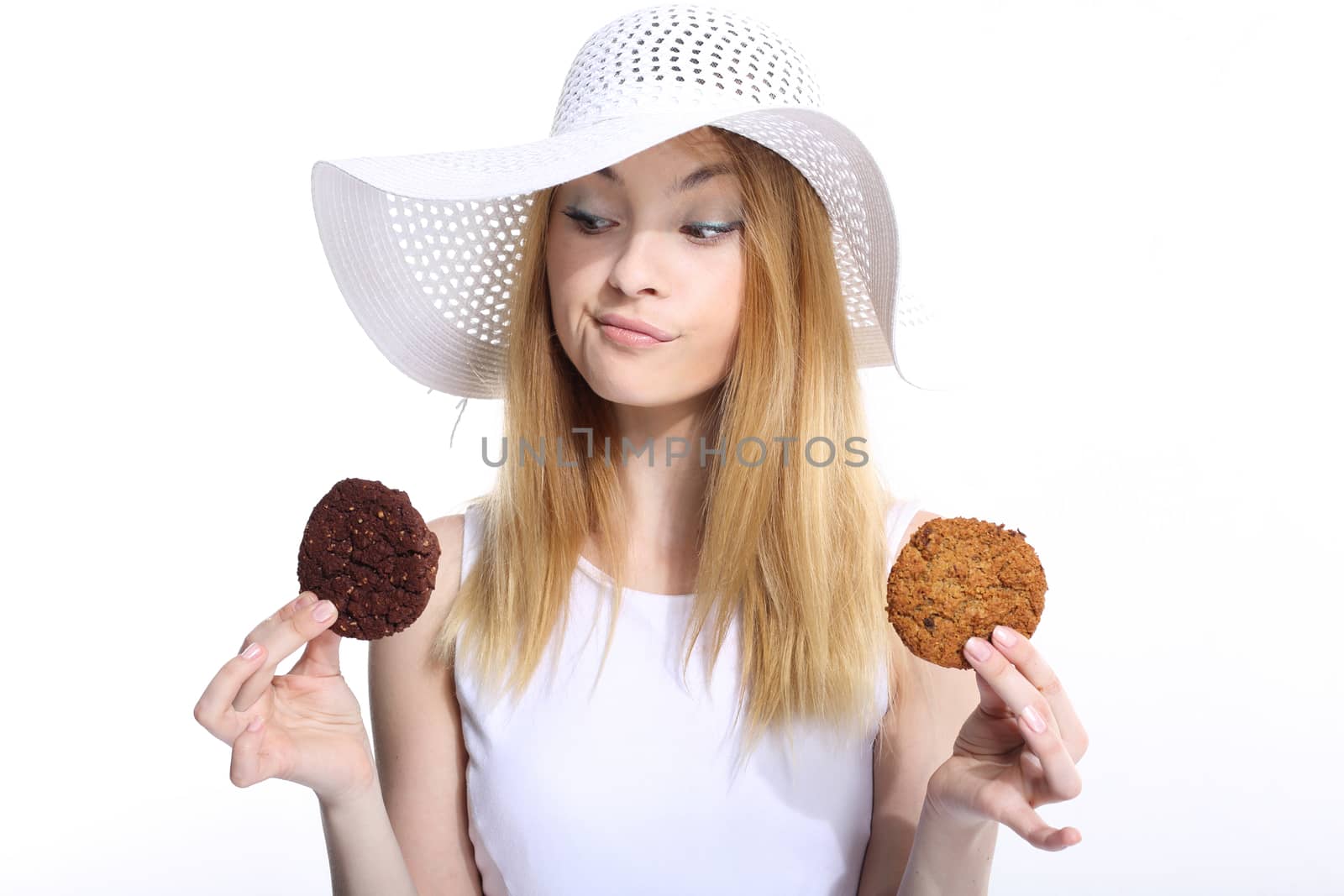 Cute young woman eats cookies on the white background