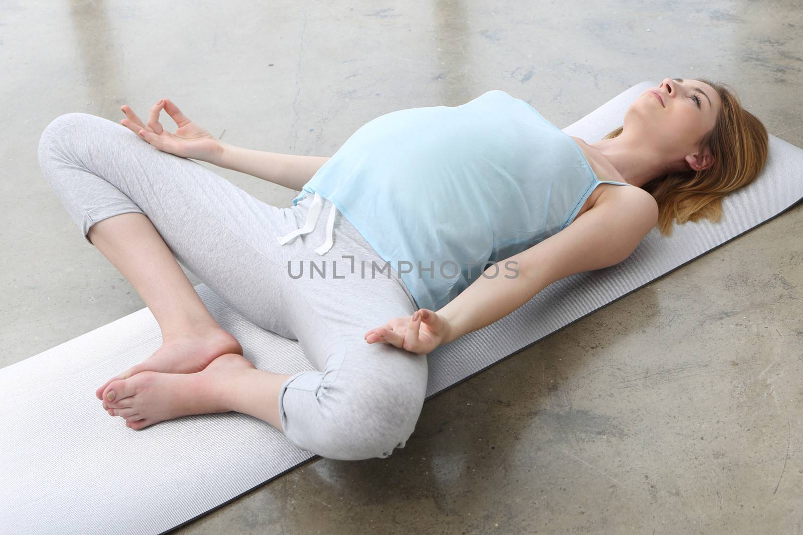 Pregnant woman doing yoga exercise by robert_przybysz