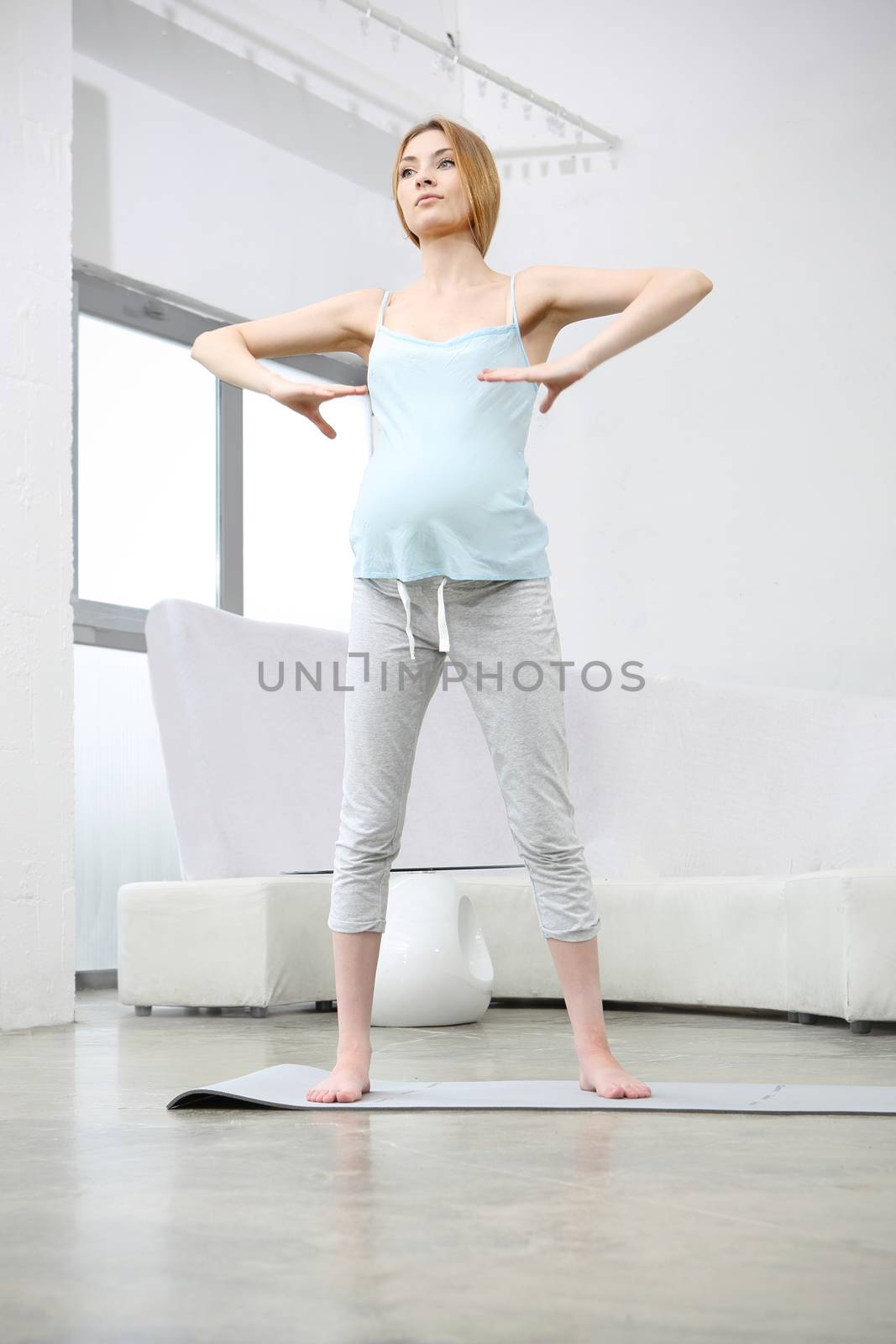 Pregnant woman doing yoga exercise by robert_przybysz