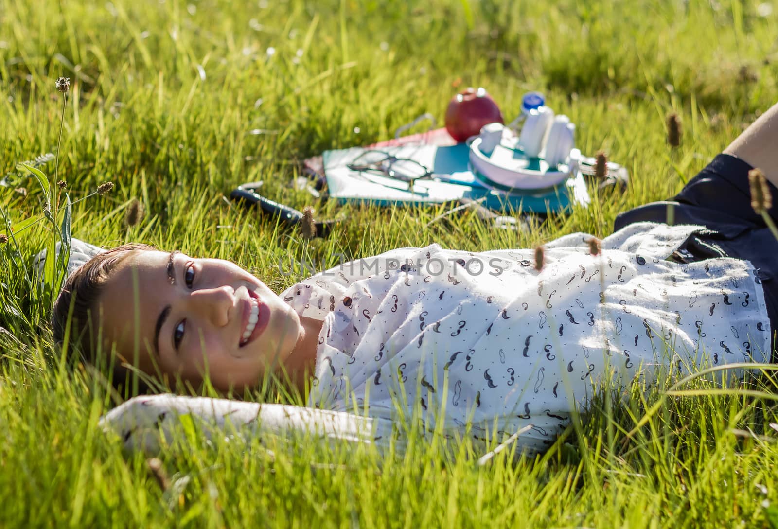 Beautiful young student lying at the park in a sunny day by doble.d