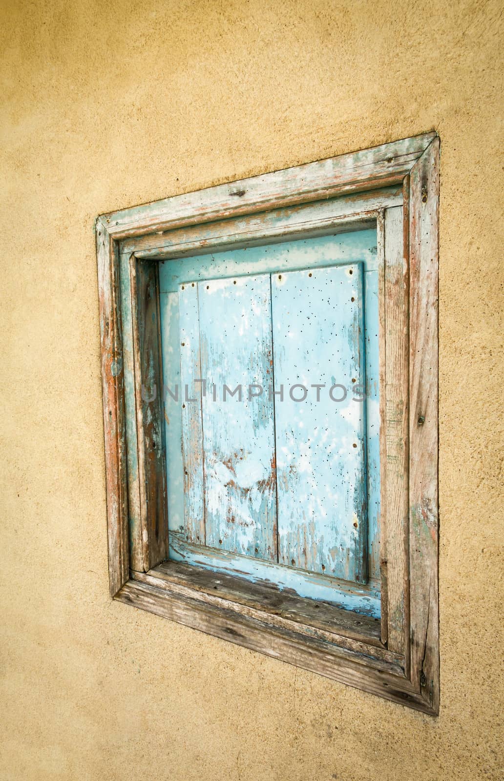Detail of small old wooden gate painted in blue and closed