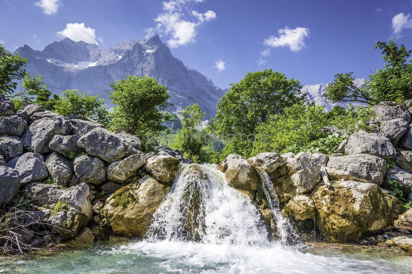 Picture of a waterfall in the Austrian Alps with trees and mountains