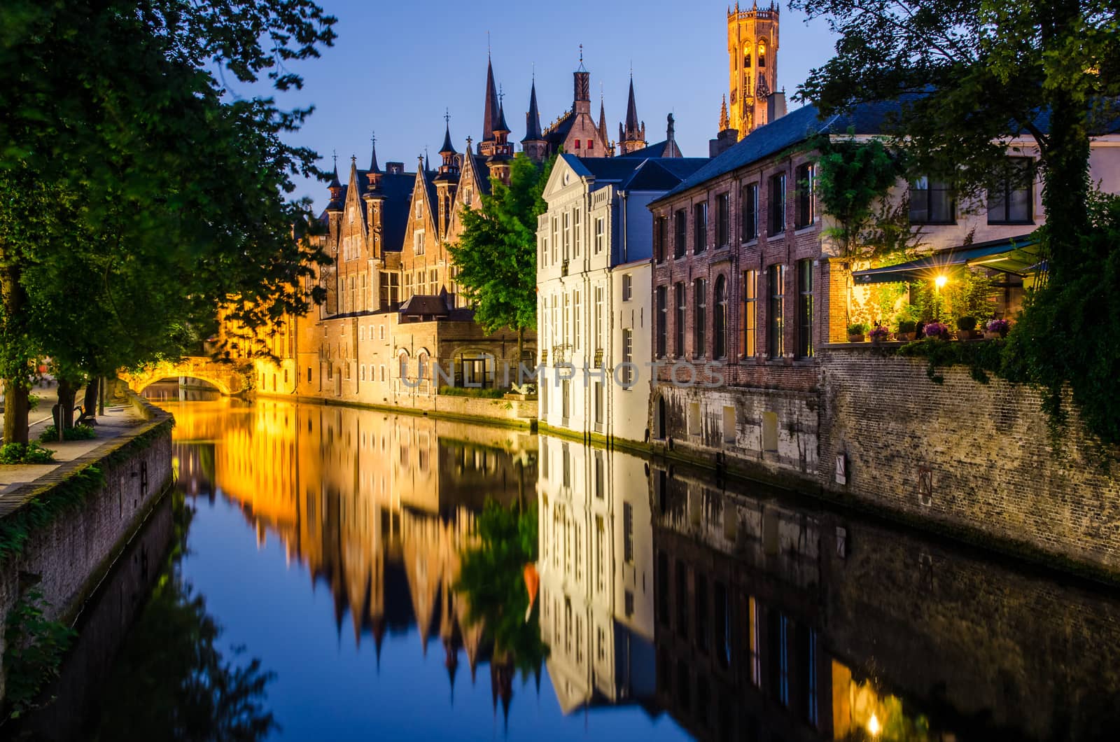 Water canal, medieval houses and bell tower at night, Bruges
