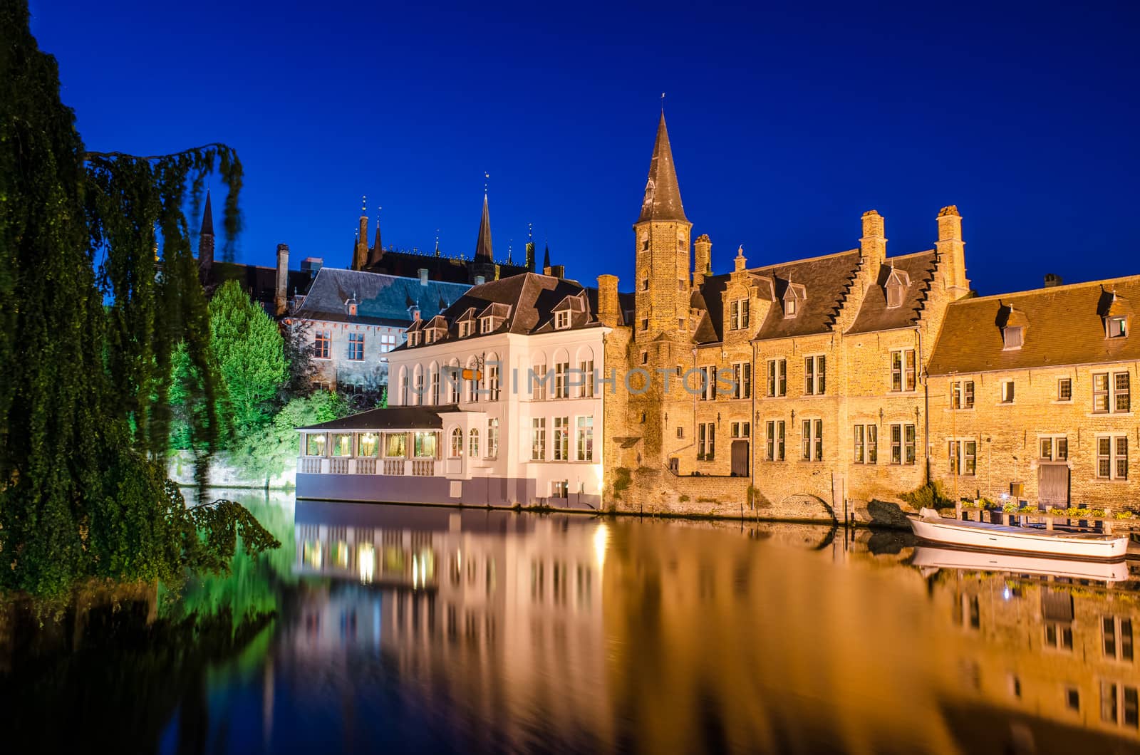 Bruges canal and medieval houses at night with water reflections, Belgium