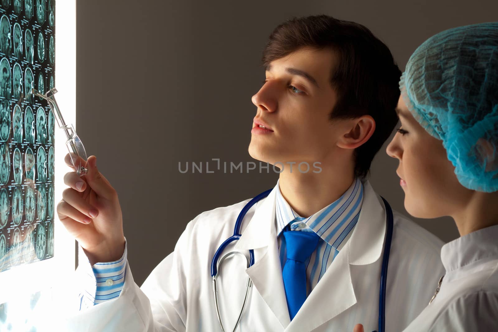 Image of two young two doctors discussing x-ray results